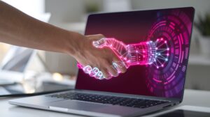Une main humaine et une main numérique s'agitent au-dessus d'un ordinateur portable, symbolisant la collaboration entre l'homme et la technologie dans des projets numériques dotés d'une intelligence émotionnelle.